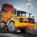 Volvo dump truck on construction site, showcasing heavy machinery used in industrial photography by Duncan MacBrayne.