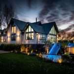 High-end residential property illuminated at twilight, showcasing architectural details and landscaped garden, highlighting Duncan MacBrayne's photography expertise for property marketing.