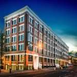 Modern brick commercial building illuminated at twilight, showcasing architectural details for property marketing.