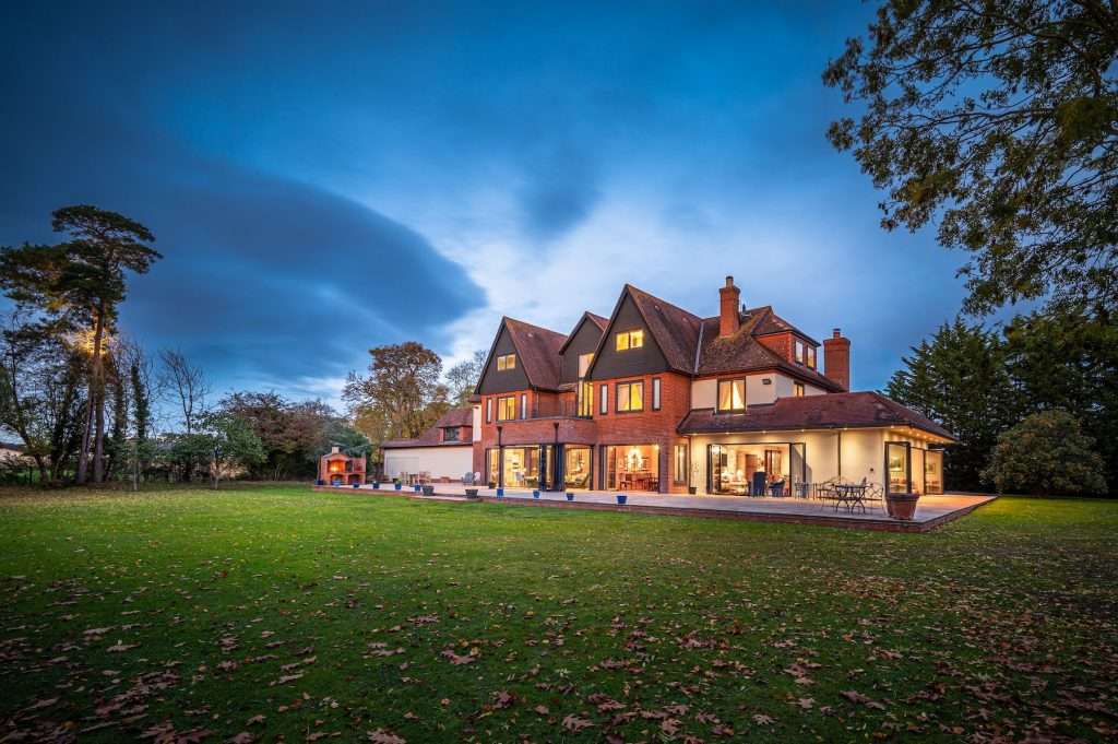 Duncan Macbrayne Commercial & Industrial Photographer Reading Berkshire Luxury eight-bedroom mock-Tudor residence with modern extensions, expansive landscaped grounds, and private pond, captured at dusk to highlight architectural features and serene setting near Windsor.