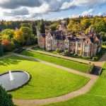 Aerial view of a luxury property with manicured lawns, a circular pond, and autumn foliage, showcasing architectural details relevant to commercial property photography in Berkshire.