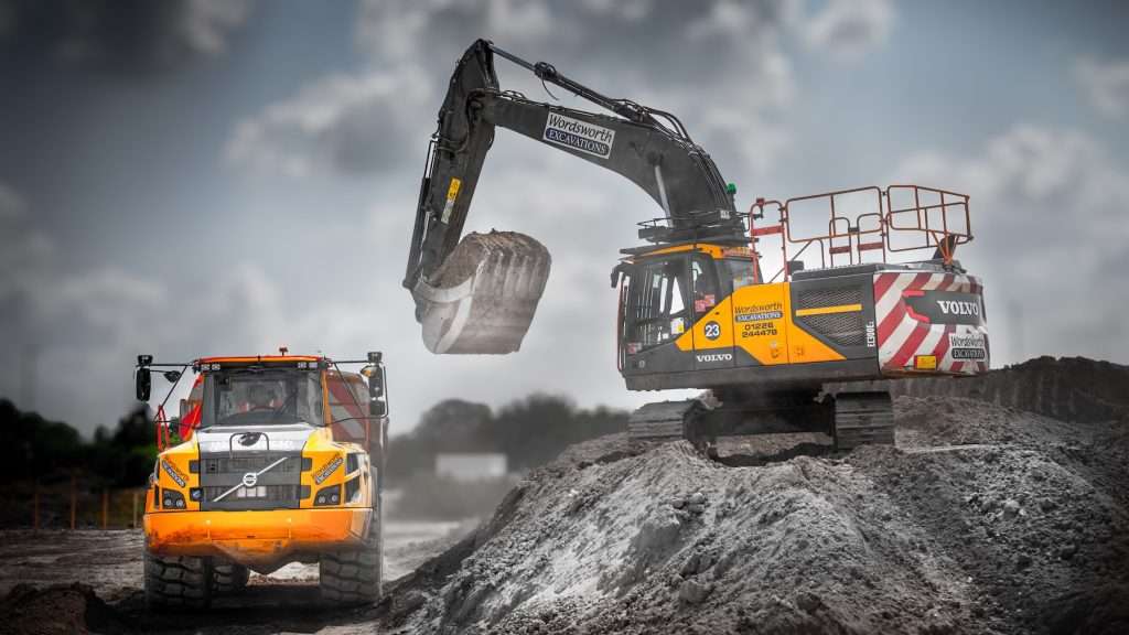 Excavator and dumper truck working on a construction site, showcasing Duncan MacBrayne's industrial photography expertise for commercial businesses.