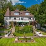 Luxury property with manicured gardens and a fountain, showcasing architectural details and a picturesque setting, relevant to Duncan MacBrayne's commercial photography portfolio in Reading and Berkshire.