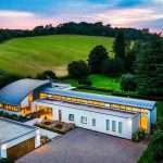 Modern luxury property in a rural setting, showcasing sleek architecture and expansive green landscape, highlighting Duncan MacBrayne's expertise in commercial property photography.