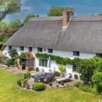 Thatched cottage with landscaped garden, showcasing residential property photography by Duncan MacBrayne, highlighting luxury home features in Berkshire.