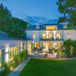 Luxury property exterior at dusk, showcasing modern architecture, illuminated windows, and landscaped garden, highlighting Duncan MacBrayne's commercial photography expertise in property visuals.