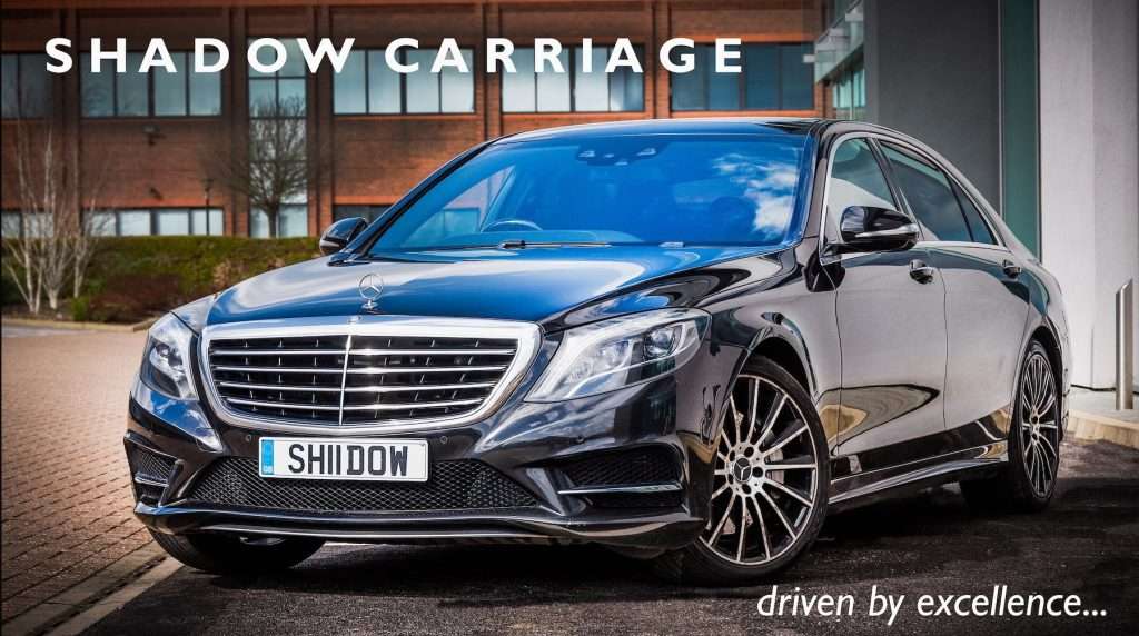 Black Mercedes-Benz luxury car parked outside a modern building, featuring the text "SHADOW CARRIAGE" and "driven by excellence," highlighting premium transportation services.