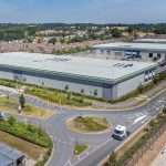 Aerial view of a modern industrial facility with landscaped surroundings and access roads, showcasing commercial property in Reading, Berkshire.