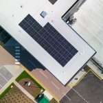Aerial view of a commercial building with solar panels on the roof, showcasing sustainable energy solutions in an industrial setting.