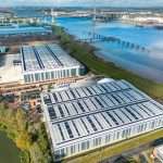 Aerial view of modern industrial buildings with solar panels, situated near a river, showcasing commercial property in Reading, Berkshire.