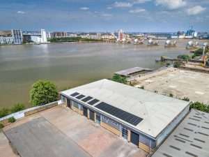 Aerial view of a commercial property with solar panels, overlooking a river and cityscape, showcasing industrial photography by Duncan MacBrayne in Reading, Berkshire.
