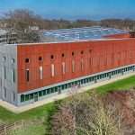 Modern commercial building with solar panels, surrounded by greenery, showcasing architectural design in Reading, Berkshire.