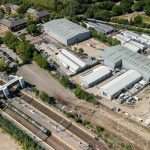 Aerial view of industrial site featuring warehouses and railway tracks, showcasing commercial property and infrastructure relevant to Duncan MacBrayne's photography services in Reading and Berkshire.
