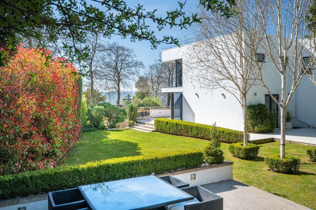 Modern luxury property with manicured garden, vibrant foliage, and sleek architecture in Reading, Berkshire.