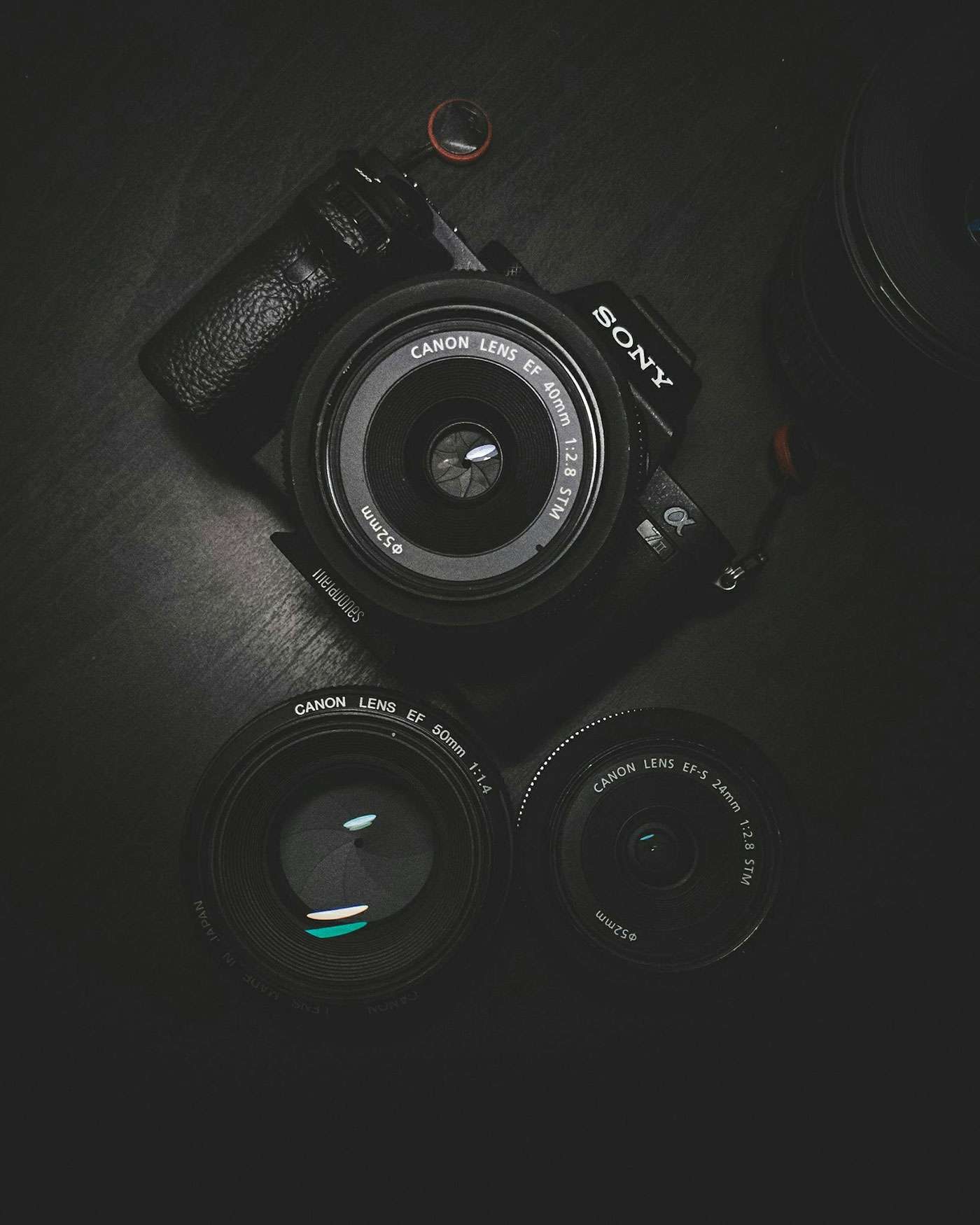 Sony camera with Canon lenses, showcasing photography equipment on a dark surface, representing Duncan MacBrayne's professional photography services.